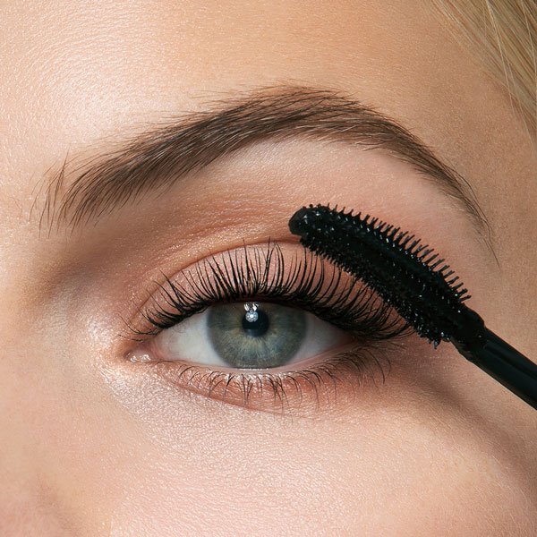 Close up of mascara wand applying mascara on eyelash