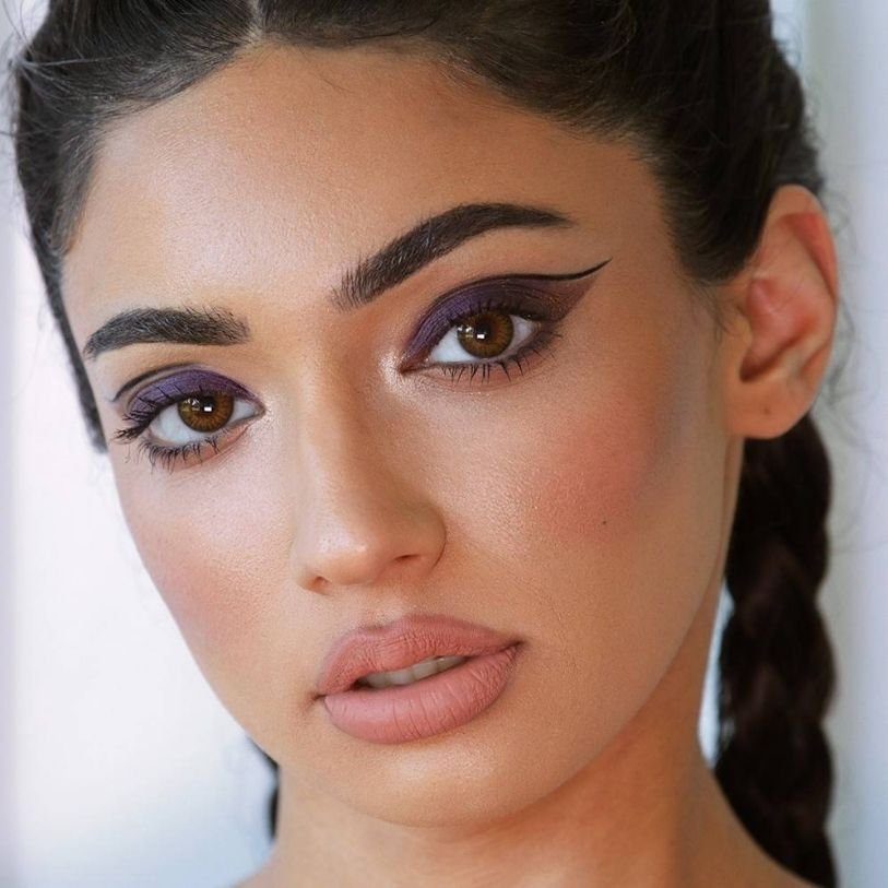 Close up of model woman wearing bold purple eyeshadow and eyeliner makeup look