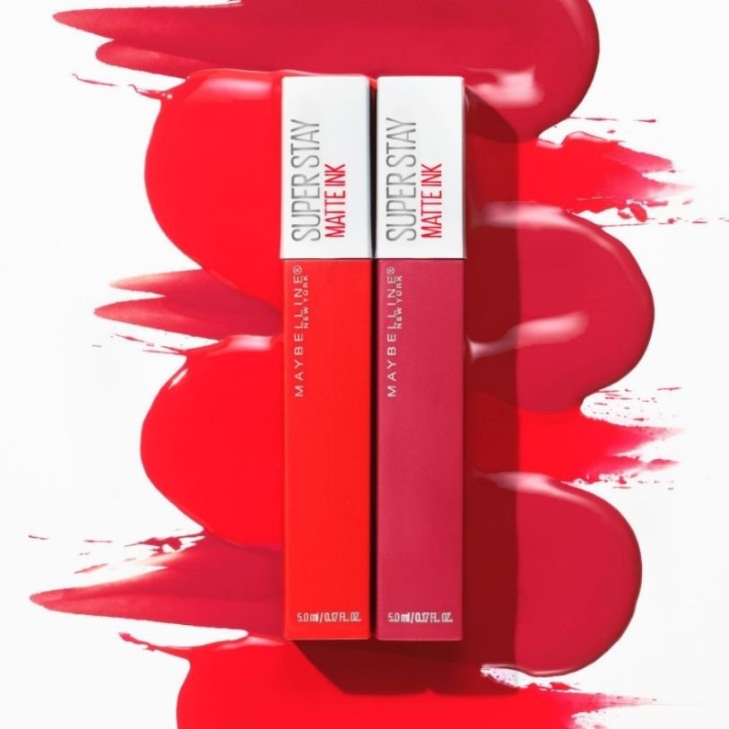 Two Maybelline Superstay Matte Link liquid lipsticks in front of red paint background