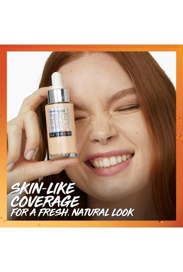 Bottle of Superstay 24H Skin Tint with Vitamin C held up by model​