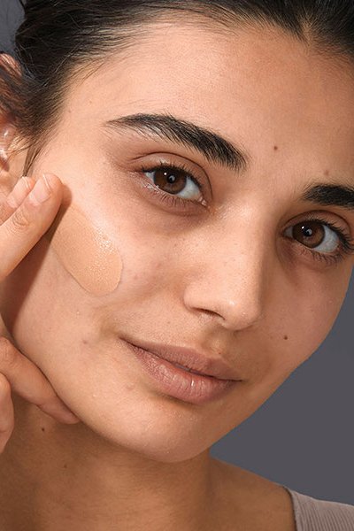 Girl Swiping Liquid Foundation On Dry Skin